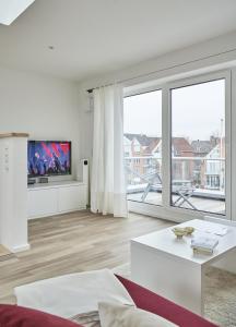 a white living room with a large window at City Marina - Haus 24A in Cuxhaven