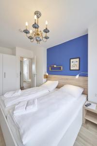 a bedroom with three beds with a blue wall at City Marina - Haus 24A in Cuxhaven