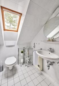 ein weißes Badezimmer mit Waschbecken und Toilette in der Unterkunft Scharhörn - 7 in Cuxhaven