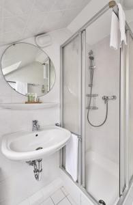 ein weißes Badezimmer mit Waschbecken und Dusche in der Unterkunft Scharhörn - 7 in Cuxhaven