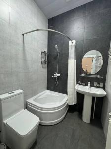 Un baño con un inodoro blanco y un lavabo. en Malika Sultan Hotel with National Boutique Museum, en Bukhara