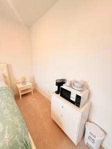 a room with a bed and a microwave on a cabinet at Cozy Retreat, Room 2, Near Mt Rainier, Seattle, National parks in Bonney Lake +2 photos