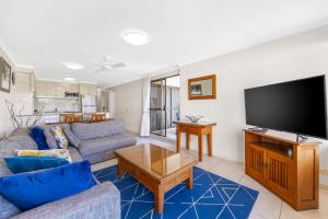 a living room with a couch and a flat screen tv at Bellardoo Holiday Apartments in Mooloolaba