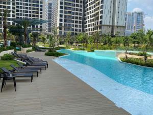 a swimming pool in a city with chairs and buildings at Honeymoon homes - Vinhomes Grand Park Quận 9 - 2 phòng ngủ in Gò Công