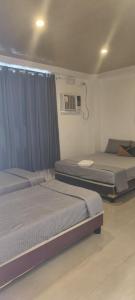 a bedroom with two beds and a air conditioner at Evas Guesthouse in General Luna