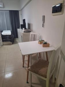 Una mesa y sillas blancas en una habitación. en Excellent Monoambiente, en Santos Lugares 1 foto más