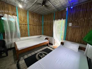 a small room with two beds and a window at DOHIKOTORA Eco Camp, Resort & Restaurant in Narjon Basti