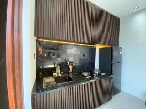 a kitchen with a sink and a refrigerator at Shinta Villa 2 Uluwatu in Jimbaran