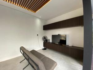 a living room with a couch and a flat screen tv at Shinta Villa 2 Uluwatu in Jimbaran
