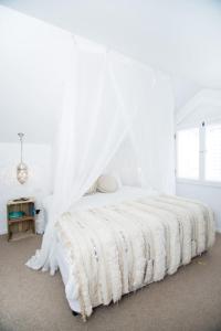 Dormitorio blanco con cama con dosel en Cactus Rose Villa - Private Stay in Byron, en Brisbane
