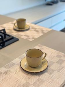 two coffee cups sitting on a counter in a kitchen at Distrito 90 luxury suites in Barranquilla