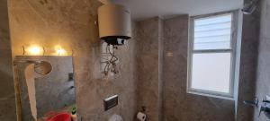 a bathroom with a light on the wall and a window at Cloud 8 Retreat in Kathmandu +16 photos