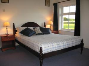 a bedroom with a bed with two lamps and a window at Tollgate Cottages Bed and Breakfast in Freshwater