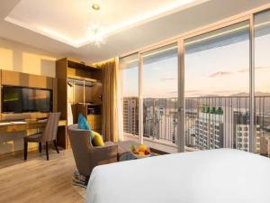 ニャチャンにあるPanorama Nha Trang Sanvillaのベッドと大きな窓があるホテルの部屋