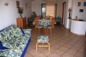 a living room with a couch and a table and chairs at B&B La Piccola Oasi in Lazzaro