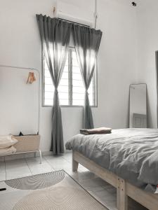 a bedroom with a bed and a window at The White Sands Homestay Pekan Pahang in Pekan