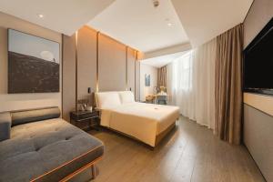 ein Hotelzimmer mit einem Bett und einem Flachbildfernseher in der Unterkunft Atour Hotel Guangzhou Zhujiang New Town Wuyangtun in Guangzhou + 24 Fotos