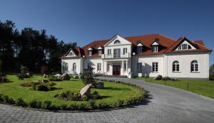 a large white house with a red roof at Folwark Ńemino in Sierakowice