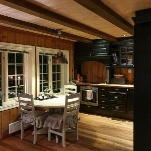 a kitchen with a table and chairs in a room at Log Cabin Near Høgevarde With Mountain Views in Granheim