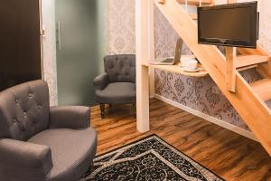 a living room with a tv and a chair at Hotel SleepInn Volkspark in Hamburg