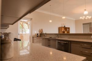 a large kitchen with a sink and a counter top at Apartment on James in Bicheno