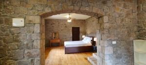a bedroom with a bed in a stone wall at Misty Views Homestay in Thekkady