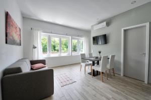 a living room with a couch and a table and chairs at Villa Oliver 2 Siófok in Siófok