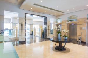 a lobby with a table with flowers on it at Maritim Antonine Hotel & Spa in Mellieħa