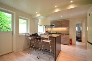 a kitchen with a island with chairs and a counter at Villa Haudalan Åndalsnes in Åndalsnes