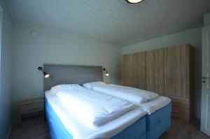 a bedroom with a large bed with white sheets at Villa Haudalan Åndalsnes in Åndalsnes