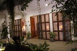 an entrance to a house with large windows and plants at Muguet House Granada in Cali +72 photos