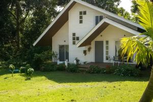 a white house with a porch and a yard at Mai 'Uta Experience in Hanga Roa