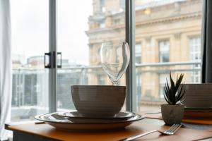 Una mesa con una copa de vino encima. en Buchanan Penthouse, en Glasgow
