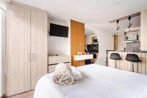 a bedroom with a bed with towels on it at Citalofty in Bogotá