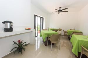 ein Esszimmer mit grünen Tischen und Stühlen in der Unterkunft Hotel Los Girasoles in Cancún