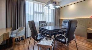 una stanza con un tavolo e delle sedie in una stanza di Borrman Hotel Nanning Anji Passenger Station Xijin Metro Station a Nanning