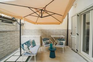 a patio with chairs and an umbrella at La Dimora delle Muse in Praia a Mare