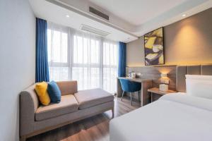 a hotel room with a bed and a couch at 7 Days Premium Hotel Chongqing Jiangbei International Airport Terminal 3 in Chongqing