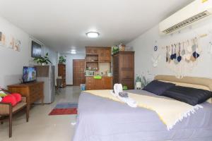 a bedroom with a large bed and a kitchen at Urban Escape-Prime Nimman Studio in Chiang Mai