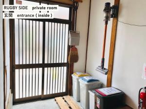 a gate in a room with two trash cans at TAKIO guesthouse RUGBY SIDE in Higashi-osaka