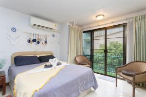 a bedroom with a bed and a balcony at Urban Escape-Prime Nimman Studio in Chiang Mai