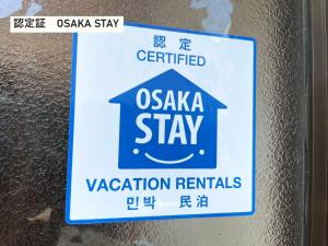 a sign on a wall that reads oasis stay vacation rentals at TAKIO guesthouse RUGBY SIDE in Higashi-osaka