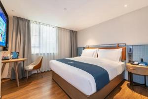 a hotel room with a large bed and a television at Echarm Hotel Guangzhou Tiyu West Raod Metro Station in Guangzhou +191 photos