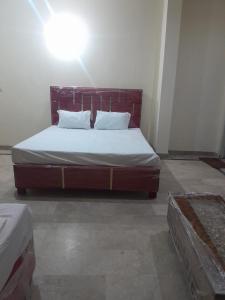 a bedroom with a bed with a wooden headboard at Galaxy Inn Hotel in Lahore