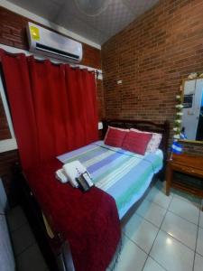 a bedroom with a bed and a red curtain at Hostal Leyendas in León