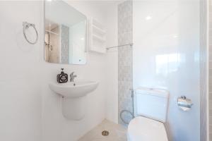 Ban KathuにあるA Nice Condo in Local Livelyhood of Kathuの洗面台とトイレを備えた白いバスルーム