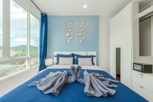 Ban KathuにあるA Nice Condo in Local Livelyhood of Kathuの青いベッドルーム(タオル付きのベッド付) +39枚の写真