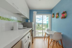 Ban KathuにあるA Nice Condo in Local Livelyhood of Kathuの青い壁のキッチン(テーブル、椅子付)