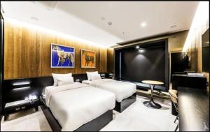 two beds in a room with a flat screen tv at Hotel Forestar in Seoul