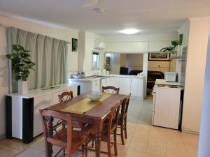 une cuisine avec une table et des chaises en bois dans l'établissement Corella Accommodation 1E, à Boulder